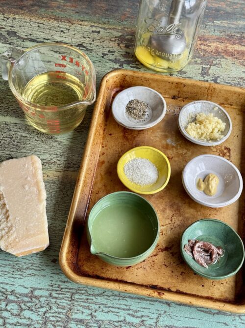 ingredients for homemade caesar dressing in small bowls