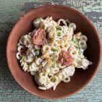 chicken caesar pasta salad in a red bowl