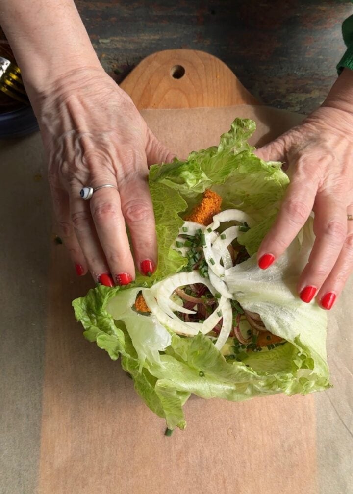 teri rolling a high protein lettuce wrap on a cutting board
