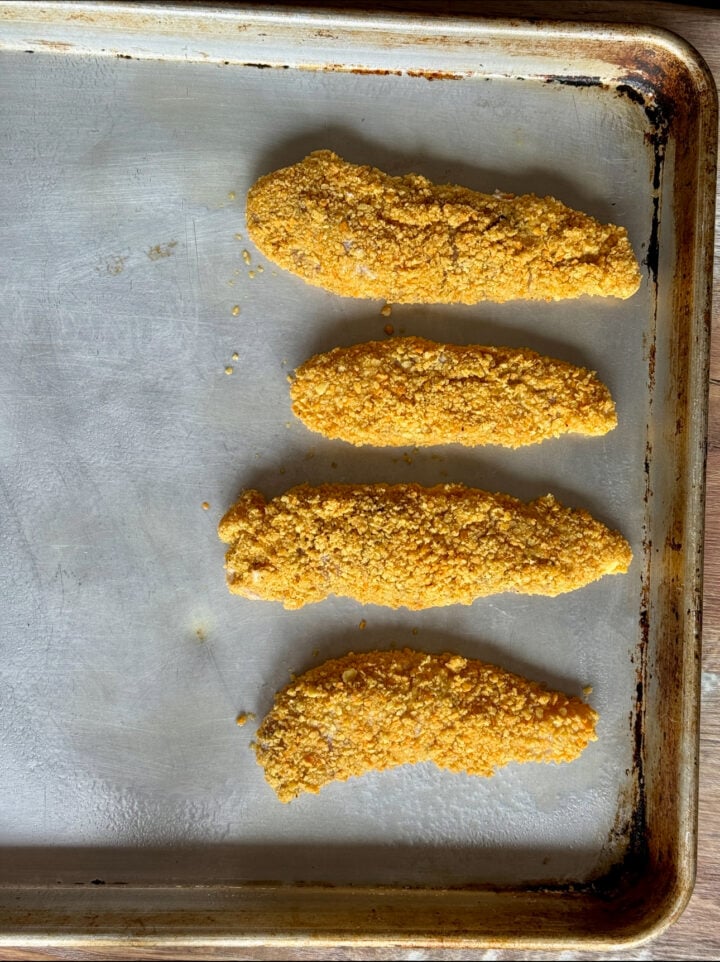 four chicken fingers on a sheet tray