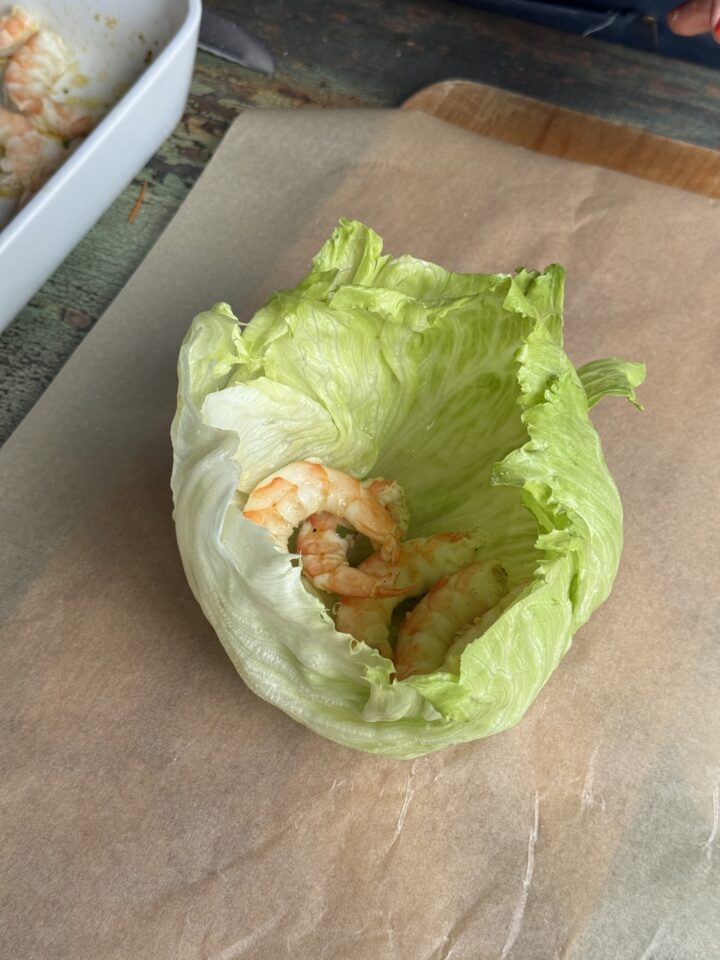 shrimp in a lettuce wrap on parchment paper