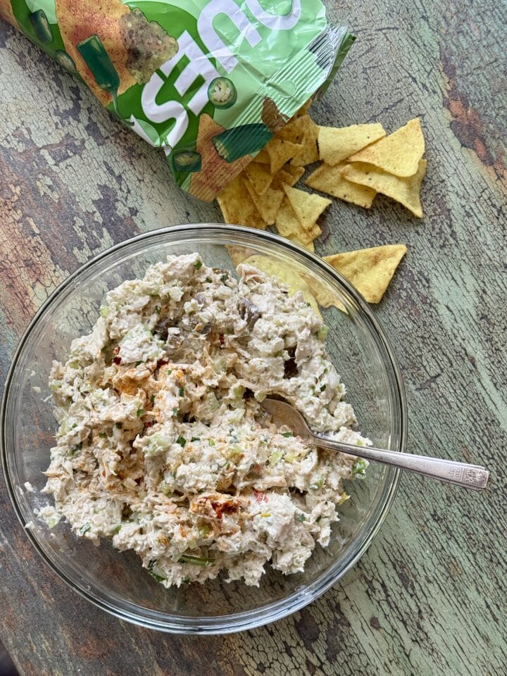 high protein chicken salad in a glass bowl with chips next to it