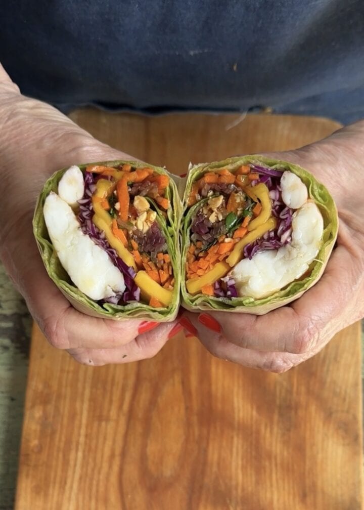 teri holding two halves of a sweet and sour shrimp lettuce wrap