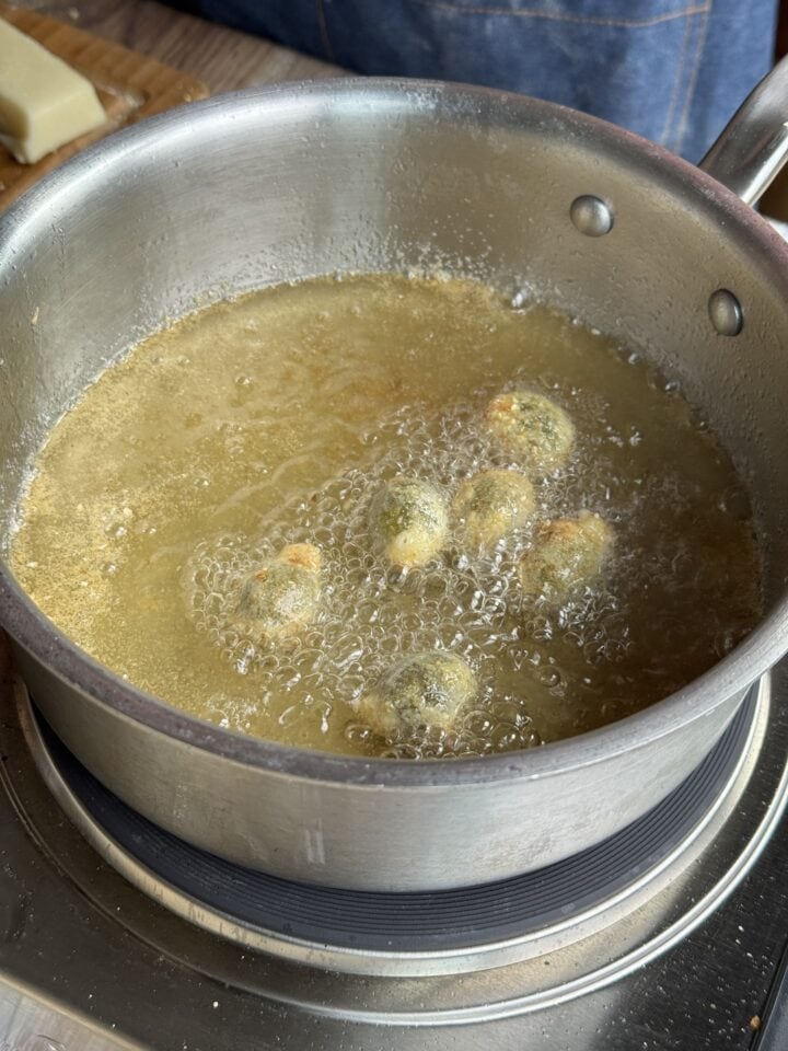 olives frying in oil in a small sauce pan