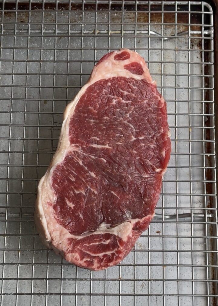uncooked steak on a wire rack