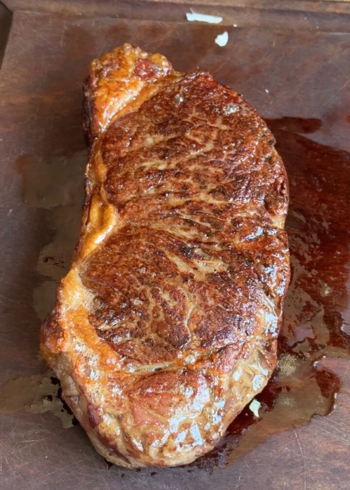 reverse sear steak on a wooden cutting board