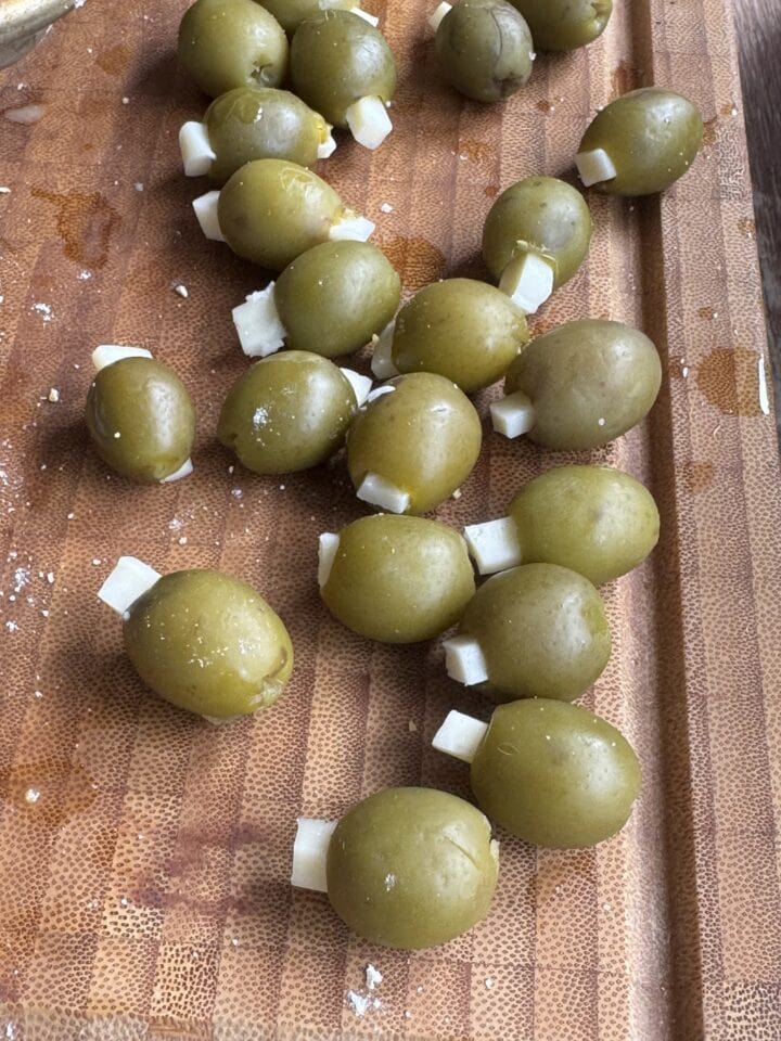 green olives stuffed with fontina cheese on a wooden cutting board