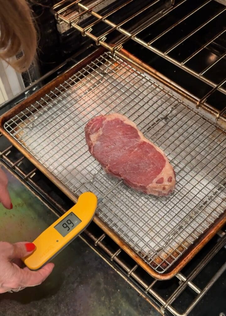 a meat thermometer in a steak in the oven