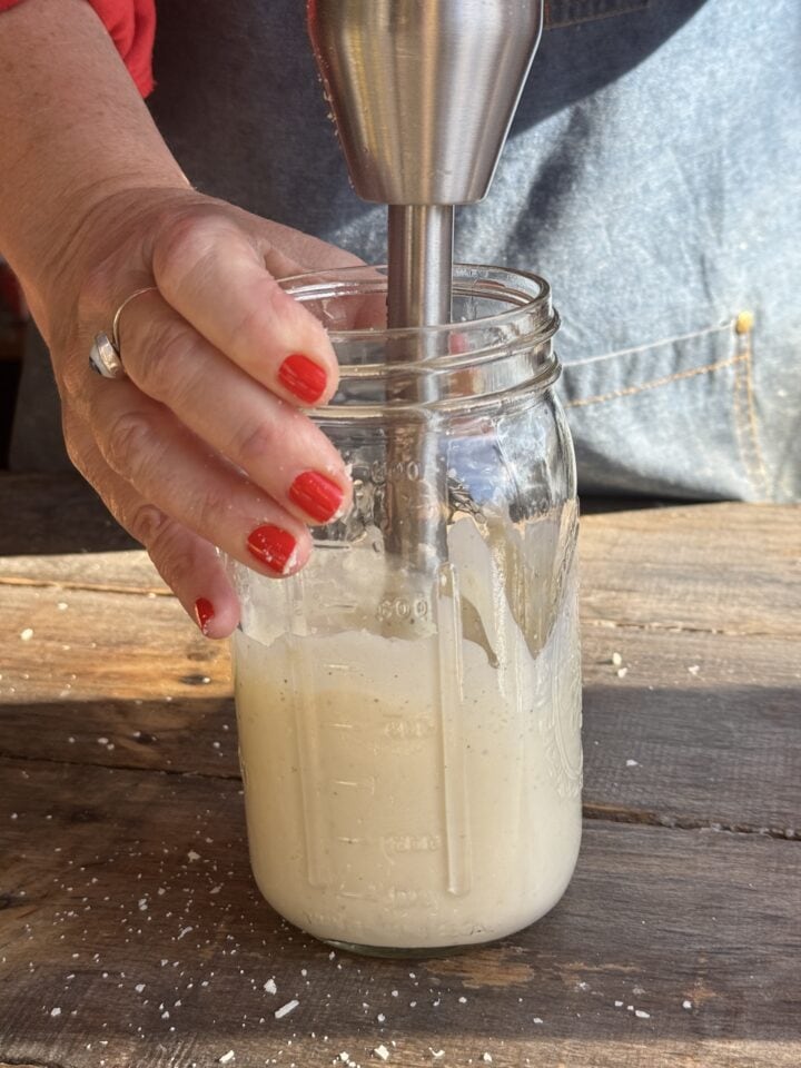 caesar mayo in a mason jar with an immersion blender in it