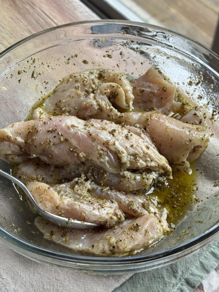 marinated chicken cutlets in a glass bowl
