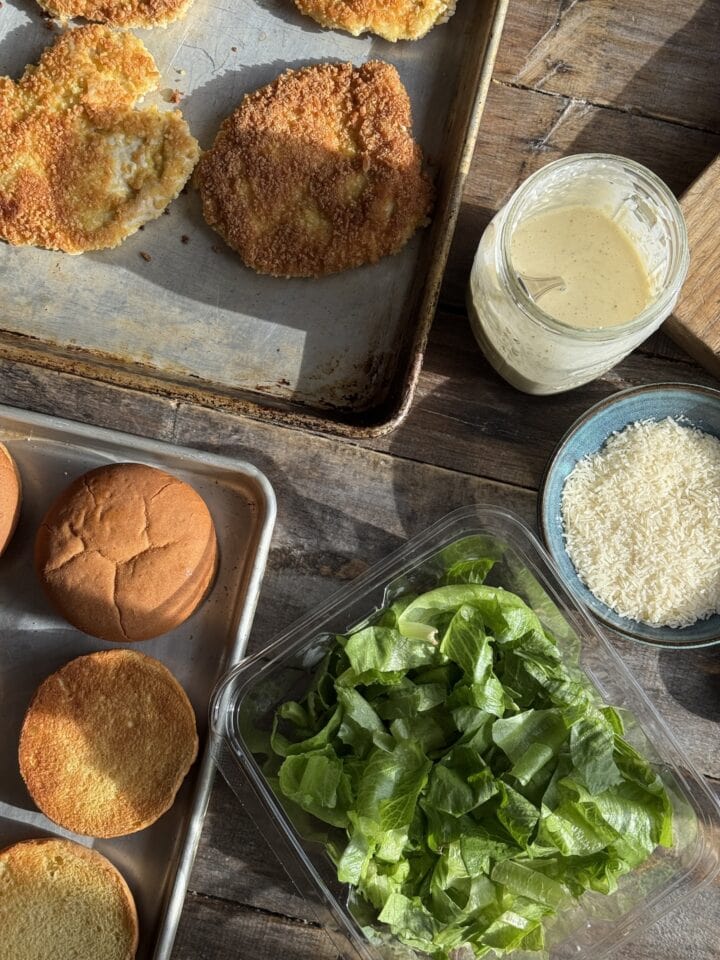 the ingredients for fried chicken caesar salad sandwich spread out on a table