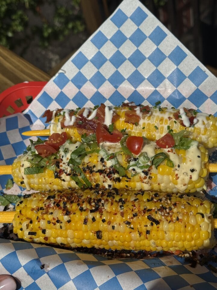 a trio of corn seasonings on corn cobs in a basket