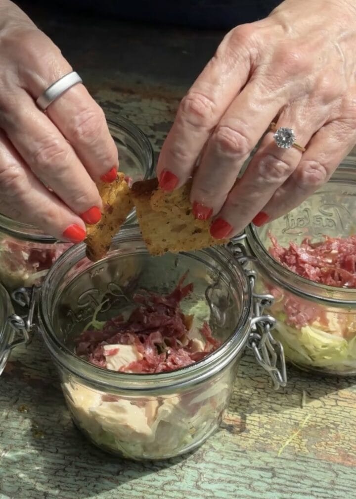 teri adding croutons to mini jars with grinder salads