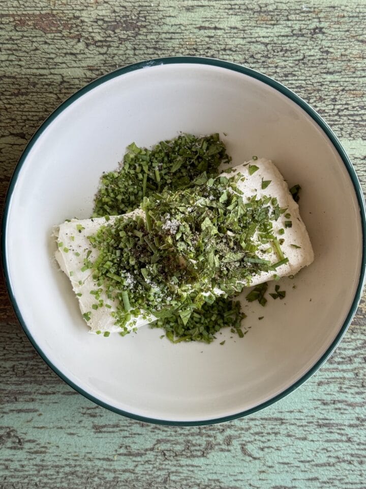 cream cheese and herbs in a white bowl