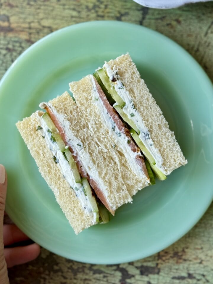 cucumber sandwich cut in half on a green plate