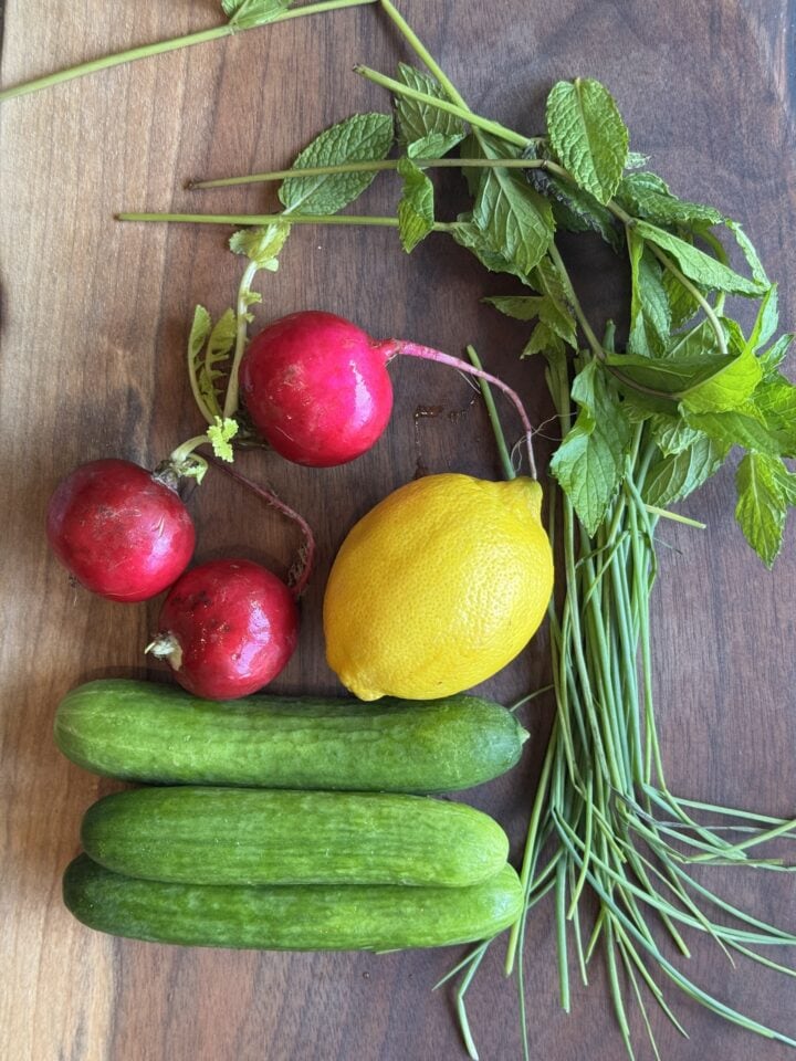 ingredients for cucumber sandwiches on a wooden cutting board
