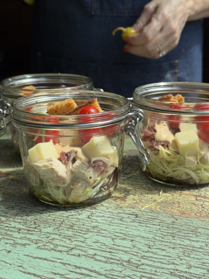 three glass jars with grinder salad in them
