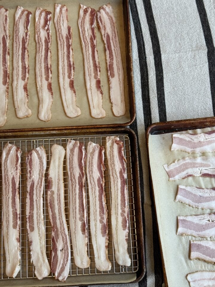 three sheet pans with bacon strips on them