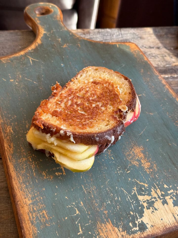 apple grilled cheese on a wooden cutting board