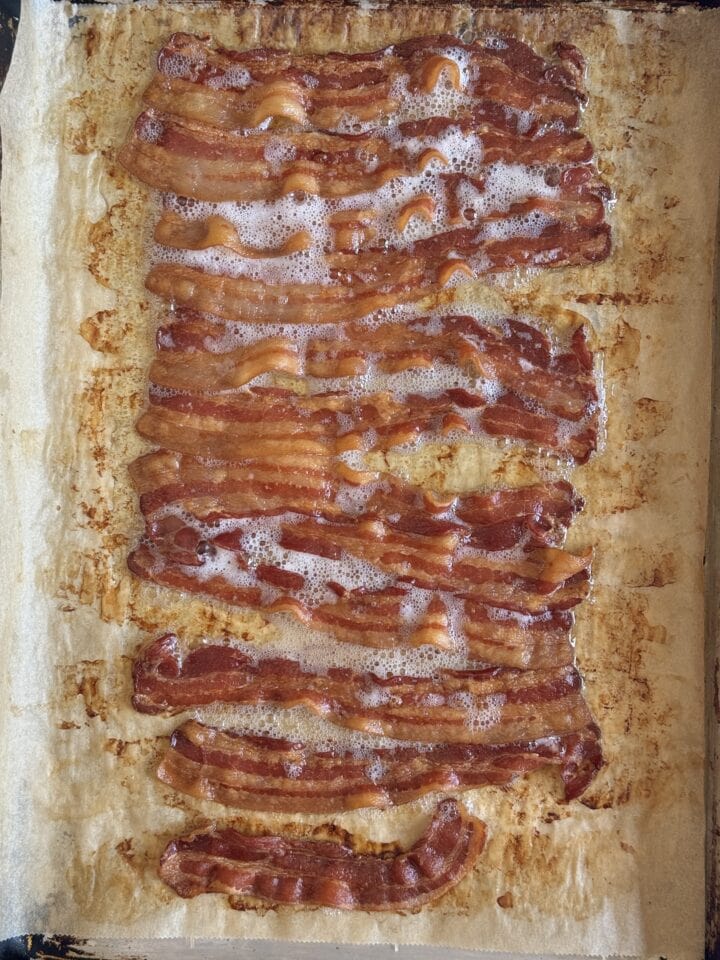 cooked bacon on a sheet pan with parchment paper