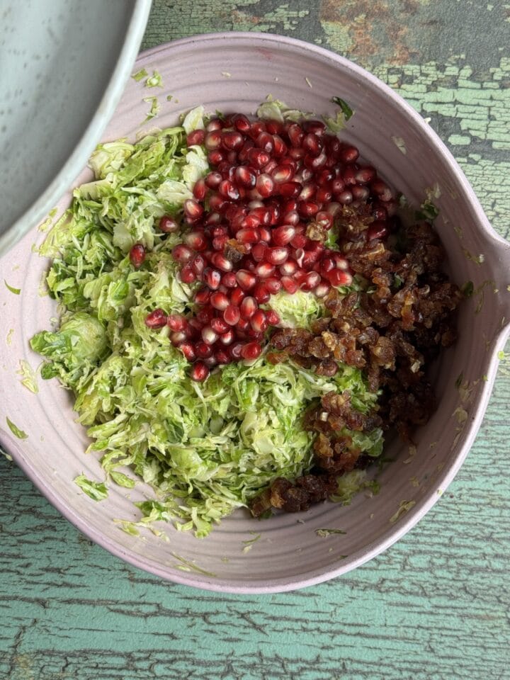 shaved brussels sprouts, pomegranate and dates in a bowl