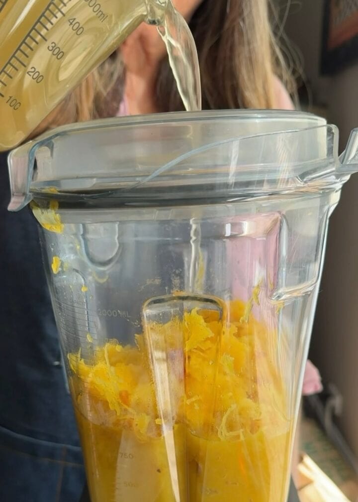 pouring chicken stock into a blender