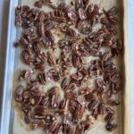 candied pecans on a baking sheet
