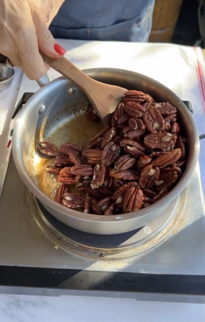 stirring pecans in pot