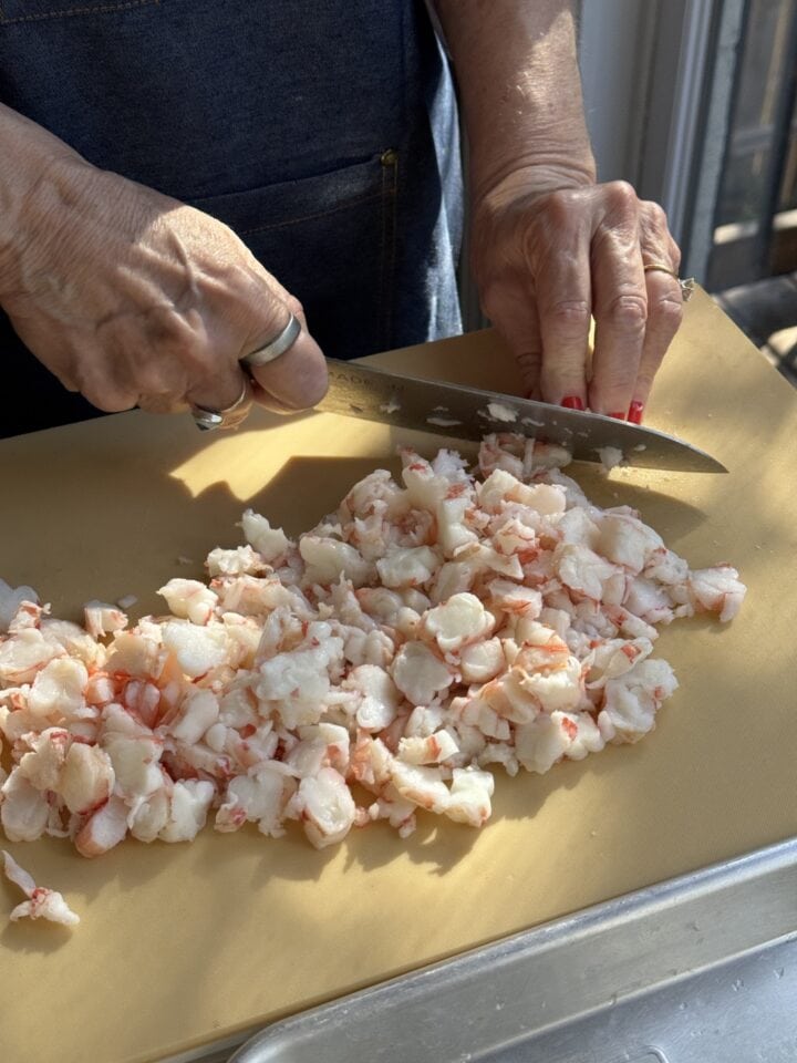 teri cutting the poached shrimp on a cutting board