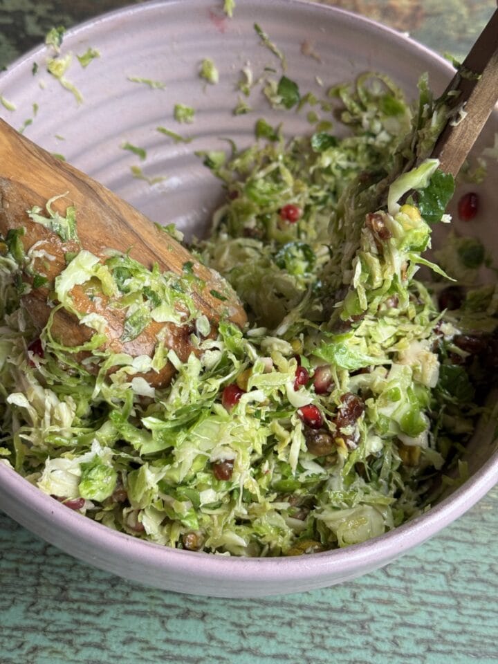 shaved brussels sprout salad with wooden spoons in it